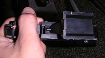 The base of the red dot finder. The base is not flat, and even has a protrusion at the end of the base (left of base) so i can't mount it nicely on the surface.
